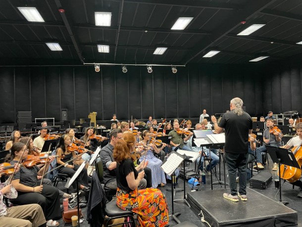 Conductor Arnie Roth leading the orchestra in rehearsal before the Los Angeles Debut.